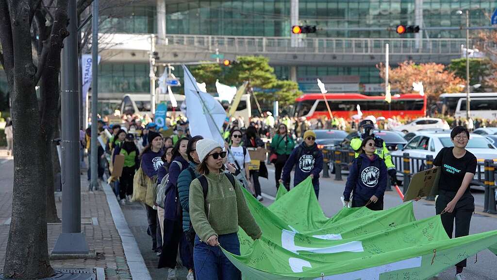香港團隊帶着寫上「走塑」願景的標語 ，到達釜山，參與韓國當地的走塑大遊行。© Greenpeace